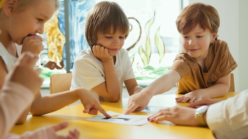 3 enfants en classe coopérant les uns avec les autres